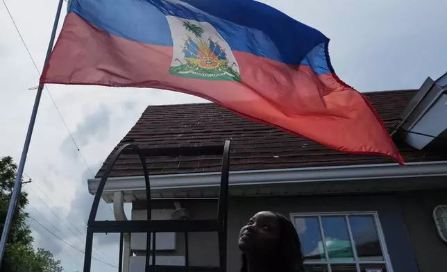 Patricia Grace Louis-Jacques, a nursing student who has close Haitian family members and friends affected by the end of TPS, poses for a photo outside the Caribbean Creole Café in Salisbury, Md., Sunday, Aug. 2, 2026. (AP Photo/Luis Andres Henao)