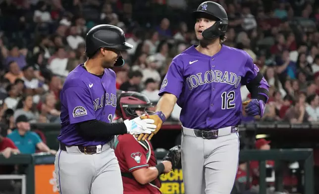 Colorado Rockies' Kyle Karros (12) celebrates with Ezequiel Tovar after hitting a two-run home run against the Arizona Diamondbacks in the first inning of a baseball game, Tuesday, Aug 11, 2026, in Phoenix. (AP Photo/Rick Scuteri)