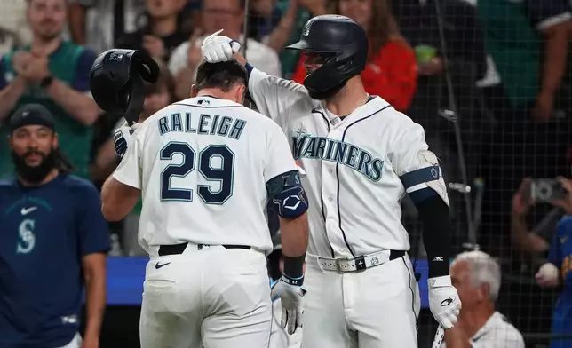 Seattle Mariners' Cal Raleigh (29) is greeted by teammate Weston Wilson after hitting a solo home run against the Philadelphia Phillies during the fifth inning of a baseball game, Monday, Aug. 24, 2026, in Seattle. (AP Photo/Lindsey Wasson)