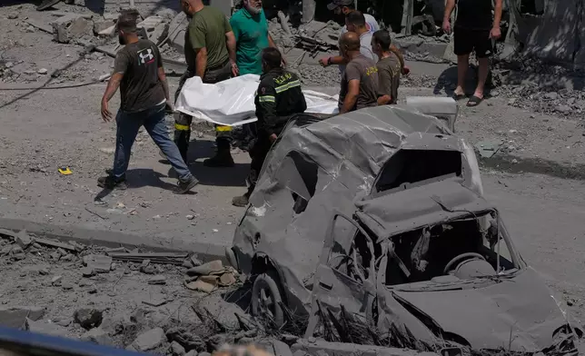Rescue workers carry a plastic bag, containing the body of a person who was killed at a house that was hit by an Israeli airstrike in Deir al-Zahrani village, southern Lebanon, Saturday, Aug. 15, 2026. (AP Photo/Mohammed Zaatari)