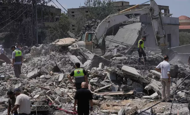 People and rescue workers gather on a destroyed house that was hit by an Israeli airstrike in Deir al-Zahrani village, southern Lebanon, Saturday, Aug. 15, 2026. (AP Photo/Mohammed Zaatari)