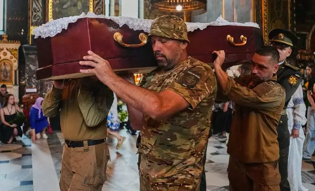 Fellow soldiers carry the coffin of Oleksiy Yukov, who was fatally wounded while exhuming bodies of killed soldiers in the frontline in Donetsk region, during farewell service in St. Volodymyr Cathedral in Kyiv, Ukraine, Saturday, Aug. 8, 2026. (AP Photo/Efrem Lukatsky)