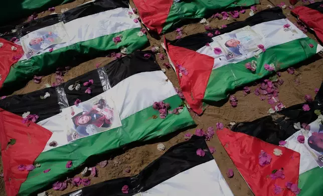 Bodies of members of the Hassayna and Abu Sharia families, killed in an Israeli strike in 2023 and recently recovered from the rubble, are draped in Palestinian flags during their funeral in Gaza City, Tuesday, Aug. 4, 2026. (AP Photo/Jehad Alshrafi)