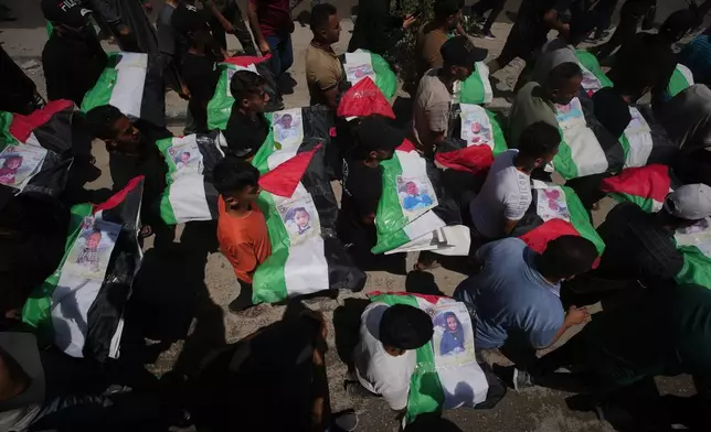 Palestinians carry the flag-draped bodies of members of the Hassayna and Abu Sharia families, who were killed in an Israeli strike in 2023 and whose remains were recently recovered from the rubble, during their funeral in Gaza City, Tuesday, Aug. 4, 2026. (AP Photo/Jehad Alshrafi)