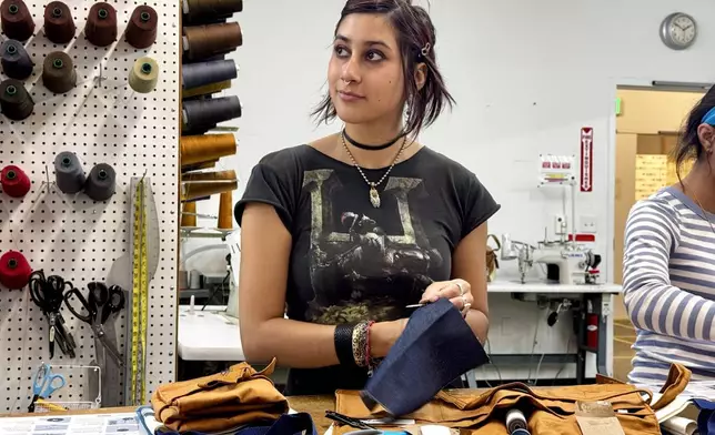 Ava Trujillo practices attends a clothing repair workshop at a Levi's retail store in downtown San Francisco, Wednesday, July 22, 2026. (AP Photo/Terry Chea)