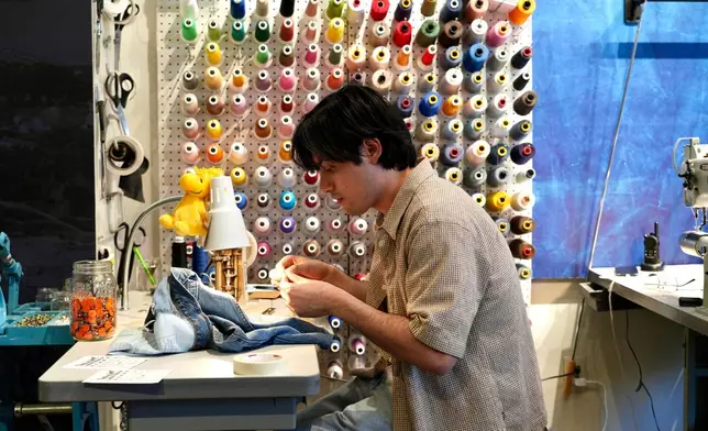 Genaro Ruiz sews clothing during a clothing repair workshop at a Levi's retail store in downtown San Francisco on July 22, 2026. (AP Photo/Terry Chea)