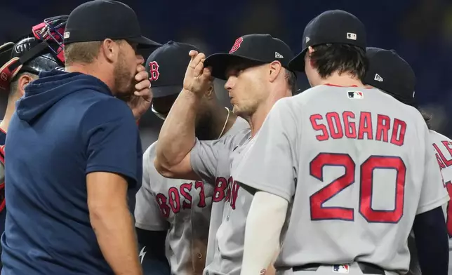 Boston Red Sox starting pitcher Sonny Gray, center, talks on the mound during the second inning of a baseball game against the Miami Marlins, Wednesday, Aug. 26, 2026, in Miami. (AP Photo/Lynne Sladky)