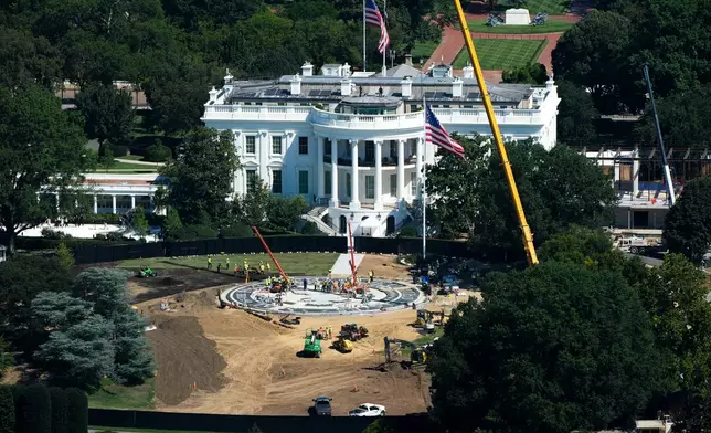 Workers build a helipad on the South Lawn of the White House, left, and continue construction on the new White House ballroom, right, as seen from the Washington Monument, Wednesday, Aug. 19, 2026, in Washington. (AP Photo/Alex Brandon)