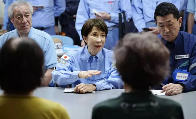 Japan's Prime Minister Sanae Takaichi meets evacuees as she visits an evacuation center in Hikawa, southern Japan, Monday, Aug. 3, 2026. (Japan Pool/Kyodo News via AP)