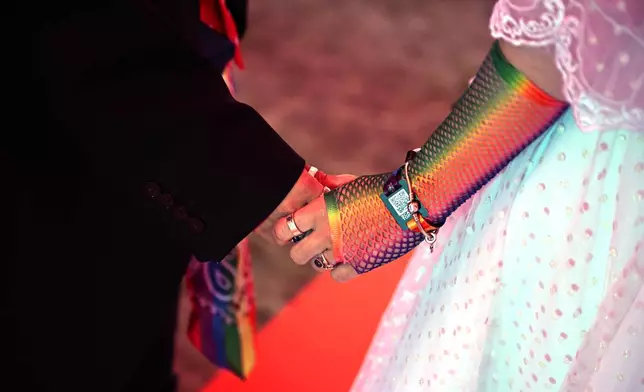 A couple exchange vows during a mass wedding ceremony in an inflatable chapel in Amsterdam, Netherlands, Thursday, Aug. 6, 2026, as part of Pride events celebrating 25 years since the Netherlands became the first country in the world to legalize same-sex marriage. (AP Photo/Mouneb Taim)