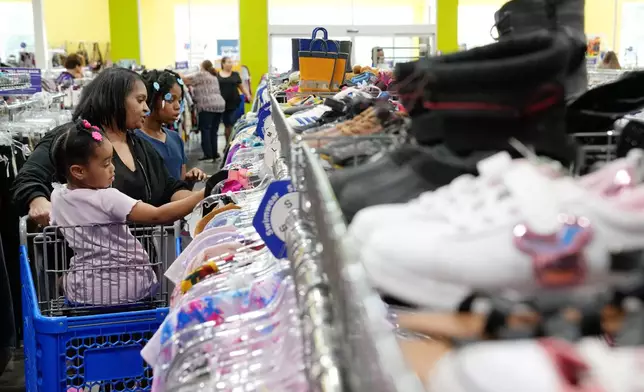 Diana Pearson and her granddaughters Deanna, 4, left, and Dai'miyonna, 9, right, shop in the children's section at a Goodwill store in Roseville, Minn., Wednesday, Aug. 12, 2026. (AP Photo/Ellen Schmidt)
