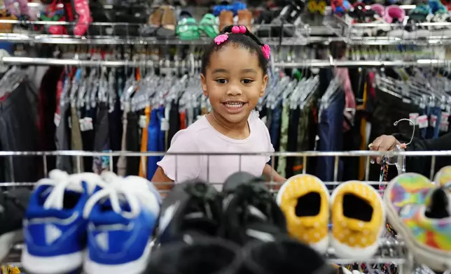 Deanna Pearson, 4, browses the children's shoe section at a Goodwill store in Roseville, Minn., Wednesday, Aug. 12, 2026. (AP Photo/Ellen Schmidt)
