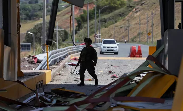 A soldiers walks through a toll plaza along the Pan-American Highway damaged in a explosion that the army blamed on FARC dissident groups in Santander de Quilichao, Colombia, Saturday, Aug. 8, 2026. (AP Photo/Santiago Saldarriaga)