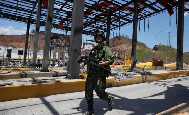 A soldier walks through a toll plaza along the Pan-American Highway damaged in a car bomb explosion that the army blamed on FARC dissident groups in Santander de Quilichao, Colombia, Saturday, Aug. 8, 2026. (AP Photo/Santiago Saldarriaga)