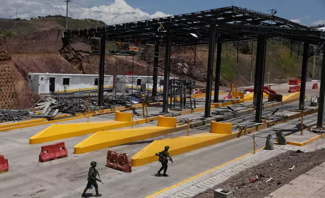 Soldiers walk through a toll plaza along the Pan-American Highway damaged in a car bomb explosion that the army blamed on FARC dissident groups in Santander de Quilichao, Colombia, Saturday, Aug. 8, 2026. (AP Photo/Santiago Saldarriaga)