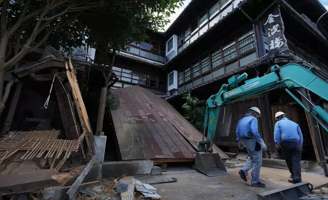 Workers inspect debris of the Kinparo inn, founded in 1910, for conservation of a possible rebuilding in Yatsushiro, southern Japan, Friday, July 31, 2026, three days after an earthquake hit the area. (AP Photo/Hiro Komae)