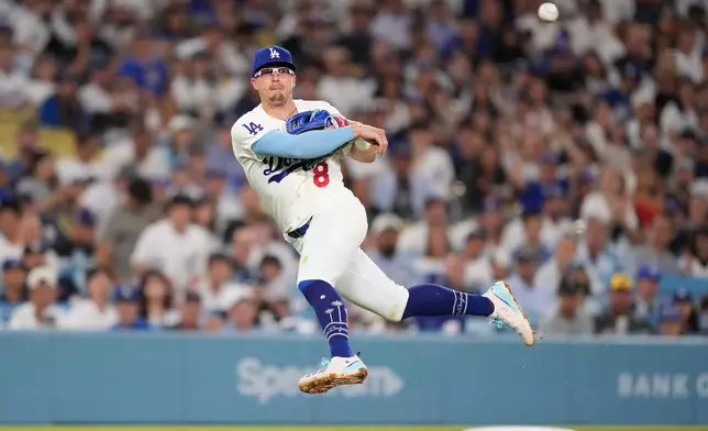 Los Angeles Dodgers third baseman Kiké Hernández throws out Milwaukee Brewers' Jake Bauers at first during the fifth inning of a baseball game Thursday, Aug. 13, 2026, in Los Angeles. (AP Photo/Mark J. Terrill)
