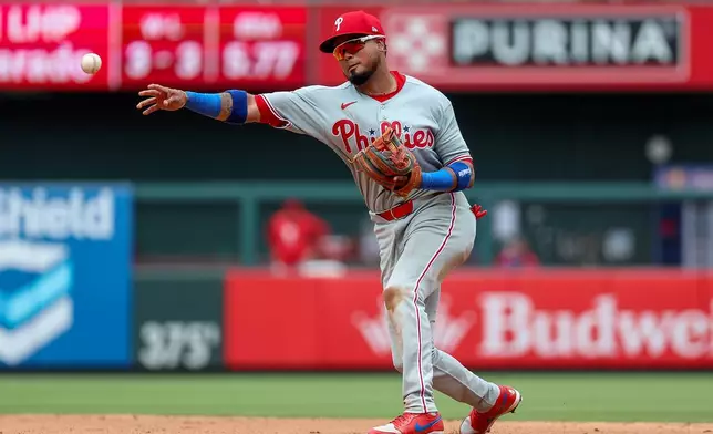 Philadelphia Phillies' Luis Arraez throws to first for an out against St. Louis Cardinals' Jimmy Crooks during the seventh inning of a baseball game Wednesday, Aug. 12, 2026, in St. Louis. (AP Photo/Scott Kane)