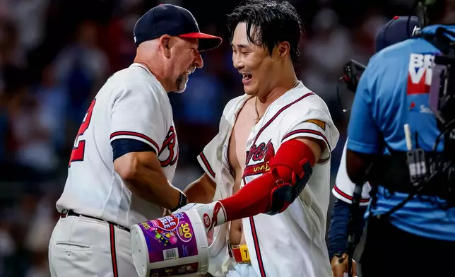 Atlanta Braves pinch-hitter Ha-Seong Kim, right, is congratulated by manager Walt Weiss, left, after Kim hit a game-winning RBI single against the Los Angeles Dodgers during the ninth inning of a baseball game, Wednesday, Aug. 26, 2026, in Atlanta. (AP Photo/Erik S. Lesser)
