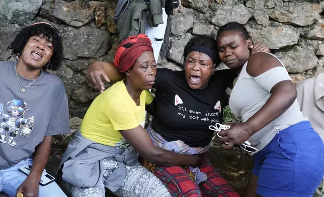 Women cry at the site where their relatives were killed in a gang attack in the Kenscoff neighborhood of Port-au-Prince, Haiti, Monday, Aug. 24, 2026. (AP Photo/Odelyn Joseph)