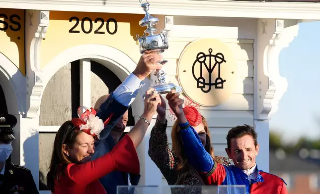 FILE - Jockey Robby Albarado, right, joins members of Swiss Skydiver's team holding the trophy after winning the 145th Preakness Stakes horse race at Pimlico Race Course, Oct. 3, 2020, in Baltimore. (AP Photo/Nick Wass, File)