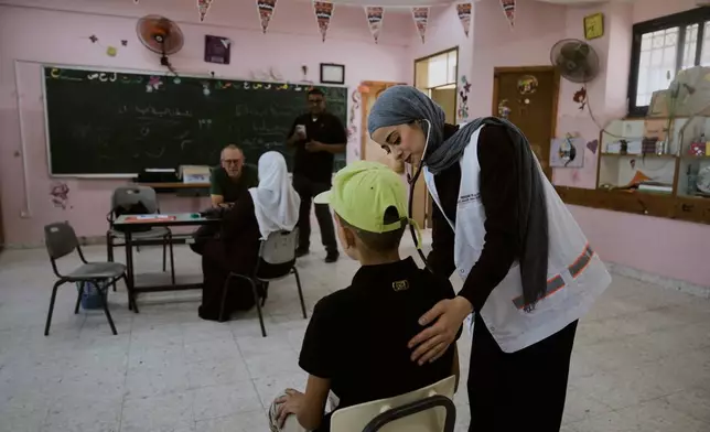 Palestinian patients receive treatment from medical staff with Physicians for Human Rights Israel (PHRI) at a mobile health clinic in the West Bank town of Iktaba, Tuesday, Aug. 4, 2026. (AP Photo/Majdi Mohammed)