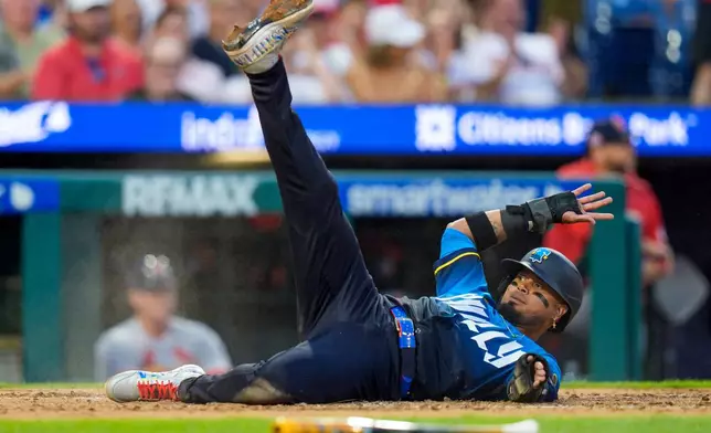 Philadelphia Phillies' Luis Arraez slides into home as he scores on a single hit by Alec Bohm during the third inning of a baseball game against the St. Louis Cardinals, Friday, Aug. 21, 2026, in Philadelphia. (AP Photo/Chris Szagola)