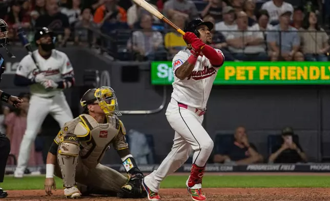 Cleveland Guardians' Jose Ramirez watches his sacrifice fly with San Diego Padres' Freddy Fermin during the fifth inning of a baseball game, Saturday, Aug. 15, 2026, in Cleveland. (AP Photo/Phil Long)