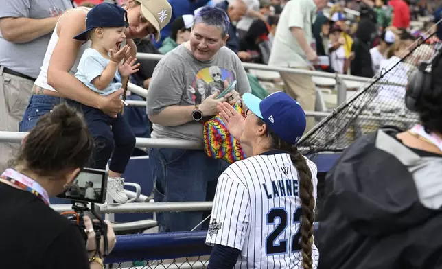 A young fan blows a kiss to New York Heights' Kylee Lahners (22) before the inaugural Women's Professional Baseball League game against the Los Angeles Queens, Saturday, Aug. 1, 2026, in Springfield, Ill. (AP Photo/Lexie Knight)