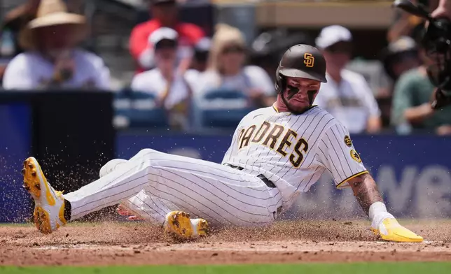 San Diego Padres' Jackson Merrill slides in to score from second base off an RBI single by Luis Rengifo during the second inning of a baseball game against the Pittsburgh Pirates Wednesday, Aug. 26, 2026, in San Diego. (AP Photo/Gregory Bull)
