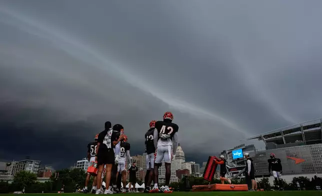 Storm clouds move in from the left during the Cincinnati Bengals' NFL football practice in Cincinnati, Tuesday, Aug. 11, 2026. (AP Photo/Carolyn Kaster)