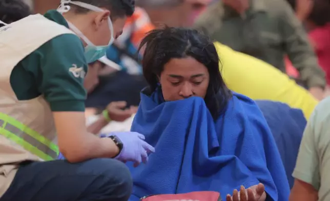 A survivor of a ferry fire receives medical attention at Tanjung Perak Port in Surabaya, East Java, Indonesia, Monday, Aug. 3, 2026. (AP Photo/Trisnadi)