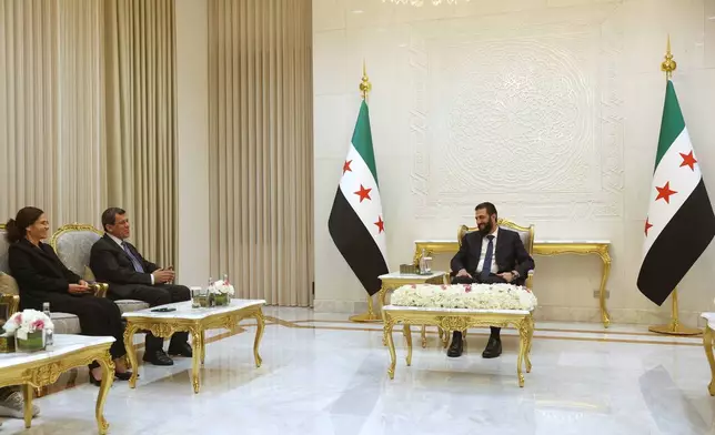Syrian President Ahmad al-Sharaa, right, meets with the commander of the Kurdish-led Syrian Democratic Forces, Mazloum Abdi, center left, at the presidential palace in Damascus, Tuesday, Aug. 25, 2026. (AP Photo/Ghaith Alsayed)