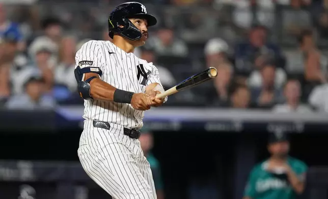 New York Yankees' Trent Grisham follows through on a home run during the fifth inning of a baseball game against the Seattle Mariners Wednesday, Aug. 12, 2026, in New York. (AP Photo/Frank Franklin II)
