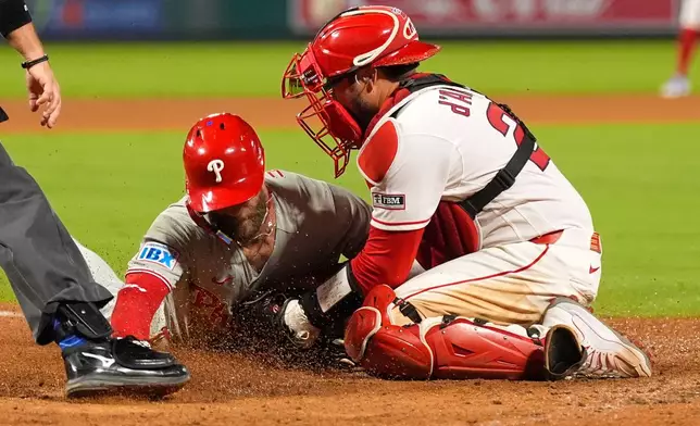 Philadelphia Phillies' Bryce Harper, left, is tagged out by Los Angeles Angels catcher Travis D'Arnaud as he tries to steal home during the eighth inning of a baseball game Saturday, Aug. 29, 2026, in Anaheim, Calif. (AP Photo/Mark J. Terrill)