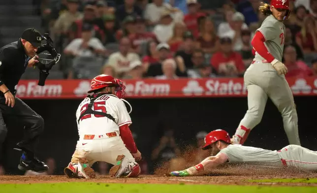 Philadelphia Phillies' Bryce Harper, lower right, is tagged out by Los Angeles Angels catcher Travis D'Arnaud, second from left, as he tries to steal home as home plate umpire Dan Merzel and Alec Bohm watch during the eighth inning of a baseball game Saturday, Aug. 29, 2026, in Anaheim, Calif. (AP Photo/Mark J. Terrill)