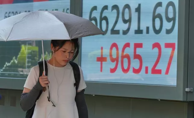 A person walks in front of an electronic stock board showing Japan's Nikkei index at a securities firm Thursday, Aug. 20, 2026, in Tokyo. (AP Photo/Eugene Hoshiko)