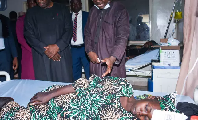 Kwara state Gov. Abdulrahman Abdulrazaq, left, visits a woman receiving medical attention at a hospital in Ilorin, Nigeria, Friday, Aug. 7, 2026, after she and others abducted by gunmen from the Woro community in February were rescued from a forest where they had been held. (AP Photo/Abubakar Khadijat)