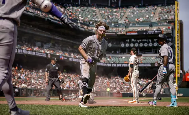 Colorado Rockies' Zac Veen, center, celebrates after he scored on a wild pitch in the sixth inning of a baseball game against the San Francisco Giants in San Francisco, Sunday, Aug. 16, 2026. (Carlos Avila Gonzalez/San Francisco Chronicle via AP)