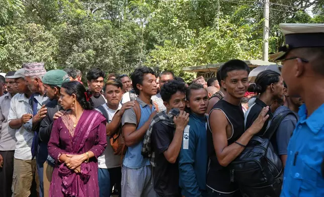 People line up outside an army camp after flash flooding in Nepal's Nuwakot district, Friday, Aug. 28, 2026. (AP Photo/Rajesh Kumar Singh)