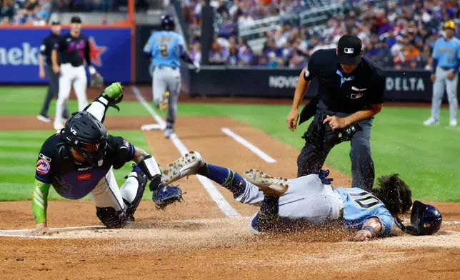 Milwaukee Brewers' fielder Sal Frelick (10) slides after being tagged out at home plate by New York Mets catcher Francisco Alvarez during the second inning of a baseball game, Wednesday, Aug. 26, 2026, in New York. (AP Photo/Noah K. Murray)