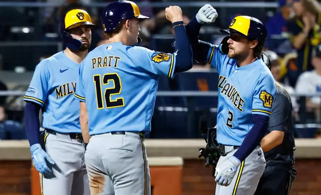 Milwaukee Brewers' Brice Turang (2) celebrates with Cooper Pratt (12) after hitting a three run home run against the New York Mets during the fourth inning of a baseball game, Wednesday, Aug. 26, 2026, in New York. (AP Photo/Noah K. Murray)