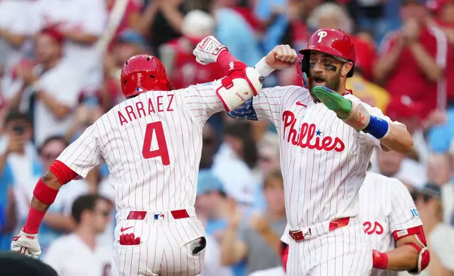 Philadelphia Phillies' Luis Arraez (4), celebrates his two-run home run with Bryce Harper hit off Miami Marlins pitcher Sandy Alcantara during the third inning of a baseball game, Wednesday, Aug. 19, 2026, in Philadelphia. (AP Photo/Derik Hamilton)