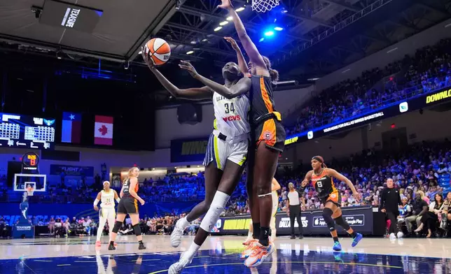 Dallas Wings forward Awak Kuier (34) shoots as Connecticut Sun's Diamond Miller, right, defends in the first half of a WNBA basketball game Sunday, Aug. 30, 2026, in Arlington, Texas. (AP Photo/Tony Gutierrez)