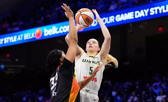 Dallas Wings guard Paige Bueckers (5) shoots as Connecticut Sun's Nell Angloma (33) defends in the first half of a WNBA basketball game Sunday, Aug. 30, 2026, in Arlington, Texas. (AP Photo/Tony Gutierrez)