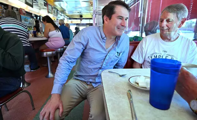 U.S. Rep. Seth Moulton, D-Mass., who is challenging Sen. Ed Markey, D-Mass. in the Sept. 1, 2026 primary, speaks to Rich Giannino of Essex, Mass., during a campaign stop at the Agawam Diner Saturday, Aug. 29, 2026, in Rowley, Mass. (AP Photo/Josh Reynolds)