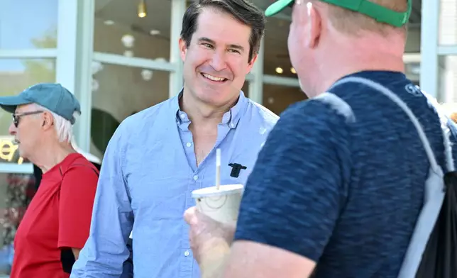 U.S. Rep. Seth Moulton, D-Mass. who is campaigning to unseat Sen. Ed Markey, D-Mass., speaks to prospective voters Saturday, Aug. 29, 2026, in Wakefield, Mass. (AP Photo/Josh Reynolds)