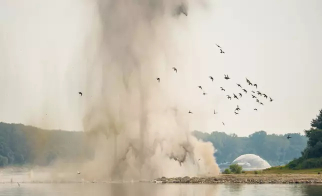 Birds fly after a controlled demolition by the Romanian Navy of submerged rocks to improve water flow to the Cernavoda Nuclear Power Plant amid exceptionally low water levels on the Danube River, in Izvoarele, Romania, Monday, Aug. 3, 2026. (AP Photo/Vadim Ghirda)