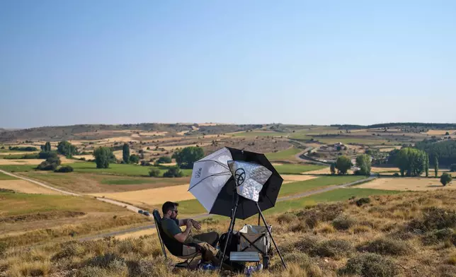 Mario Garrido, a member of the "Los Taraos" amateur astrophotography group, waits to shoot a total solar eclipse in Berlanga de Duero, central Spain, Wednesday, Aug. 12, 2026. (AP Photo/Bernat Armangue)
