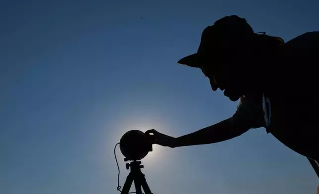 A member of the "Los Taraos" amateur astrophotography group, sets up his camera to shoot a total solar eclipse in Berlanga de Duero, central Spain, Wednesday, Aug. 12, 2026. (AP Photo/Bernat Armangue)